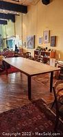 Full room view showing assembled dining table with bowed long edges and koa legs in situ.