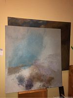 Front side of one abstract painting showing blue, beige, purple, and brown mixed colors with soft blending and textured surface.