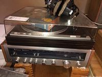 Yamaha turntable stacked on Kenwood receiver with headphones and cable on top