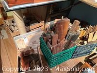 Mixed wood pieces of various shapes and sizes in plastic and wooden crates, including planks, blocks, and irregular forms