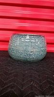 Full view of round blue ceramic plant pot with speckled glaze finish.