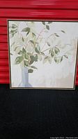 Front view of square floral art printed canvas inside driftwood look floating frame, showing foliage in vase with muted color palette