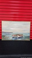 Front view of framed canvas art print featuring two canoes on calm water with distant shoreline and sky.