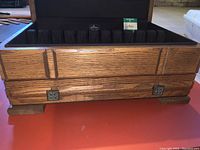 Front view of the open vintage storage chest showing the black Pacific Silvercloth lining and upper storage compartment inside a hardwood case with detailed wood grain and decorative hardware.