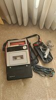 Full set showing cassette recorder, wired microphone coiled, and carrying case on carpet
