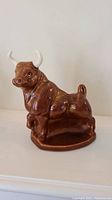 Front and side view of brown and cream ceramic bull planter with detailed bull features and creamy white horns.