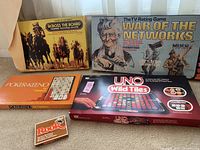 Four vintage board and card games grouped on the floor showing full box fronts and contents for Poker-Keeno.