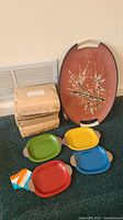 Four sets of four small trays each in original boxes, and one large vintage decorative oval tray with wrapped handles, showing all trays and boxes.