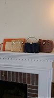 Four vintage wicker purses displayed on a mantel, showing the variety in styles and colors in the lot.