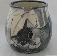 Close-up photo of the ceramic pitcher showing the front cat painting and spout.