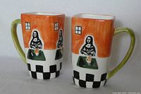 Two ceramic coffee mugs with Mona Lisa design from front angle showing artwork and shape.