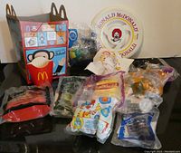 Overview of all lot items including Happy Meal toys sealed and opened, McDonald's frisbee, Paul Frank McDonald's box and fries container