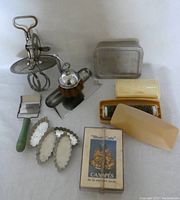 Full lot of 8 antique kitchen utensils on white background showing all pieces including egg beater, freezer box, cheese slicer, crumb sweepers, dust pan and brush, tart pans, and canape cutters