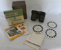 View-Master stereoscope device, original box, instruction pamphlets, and five picture reels shown on a white background