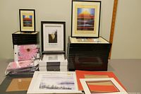 Overview of black photo frames stacked in two sizes along with clear clip frames and photo mats lying flat