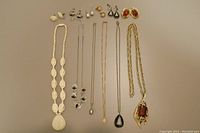 All six necklace and earring sets laid out on neutral background.