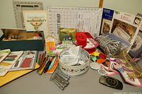 Wide shot of assorted craft and sewing items including kits, patch sets, beads, and patterned accessories.