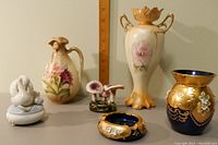 Overview photo of all items including urn, jug, blue vase, blue ashtray, swan figurine and flower frog.