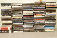 Wide view of stacked CDs showing a variety of music genres and audiobook cases in jewel and slim casings.