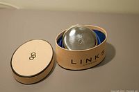 Silver compact with engraved top inside original Links of London box lined with blue fabric, lid beside box.
