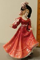 Front view of Royal Doulton porcelain figure "Patricia" in a flowing red dress, with a height ruler in the background showing about 9 inches tall.