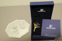 Three items: Swarovski flower brooch in original box with certificate, small Swarovski crystal rabbit figurine, non-Swarovski oyster with imitation pearl on mirrored base