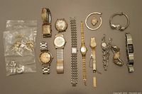 Overview of all watches and bag of parts on gray background