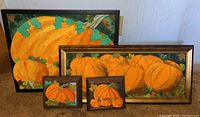 Four framed mixed media pumpkin artworks displayed together showing size differences and framing details.