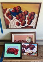 Photo showing all four framed acrylic paintings by Donald Gotz featuring apples arranged in different compositions.