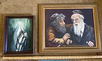 Two framed acrylic paintings by Donald Gotz side by side on carpet; one titled "Zalman and the Rabbi" and the other showing a praying Tallit-covered figure.