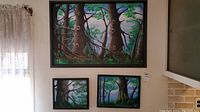 Three framed acrylic paintings mounted on a wall depicting forest scenes with detailed tree trunks and foliage, signed by Donald Gotz.