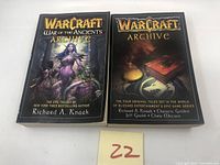 Front covers of both Warcraft Archive books showing distinct cover art of 'Warcraft Archive' 2002 and 'Warcraft War of the Ancients Archive' 2004 by Richard A. Knaak.