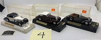 Photo shows three original vintage Solido die cast model cars on display bases, each in original clear plastic case with minor wear. Models are Mercedes Benz, Delage, and Talbot from late 1930s.