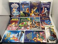 Front view of 12 VHS tapes including Disney Cinderella, Lion King, Beauty and the Beast, Aristocats, and others.