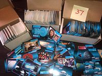Three opened cardboard boxes filled with Star Trek The Next Generation trading cards, showing loose colorful cards laid out in front.