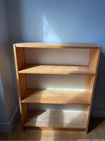 Full front view of wooden bookcase showing four shelves, two adjustable.