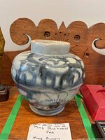 Front view of the blue and white ceramic jar with visible Ming Dynasty style patterns and some crazing.