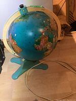 Photo of the Fisher Price light-up globe on its turquoise stand with the world map visible.
