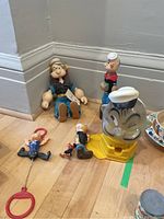 Photo showing all items including the large Popeye gumball machine and the four Popeye dolls plus Olive Oyl figurine arranged on floor.