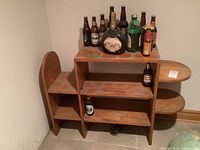 Wood shelf with bottles on top and below for scale, showing the structure and condition including noticeable scratches and wear.