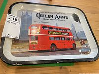 Full view of metal serving tray showing the vintage Queen Anne Rare Scotch Whisky advertisement with a red double-decker bus and London landmarks.