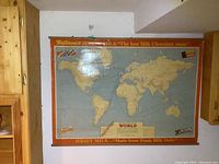 Full view of vintage Neilsons Jersey Milk Chocolate branded world map with red border and age-related cracking.