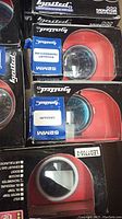 Close-up image of several Ignited Performance 52mm gauges sealed in original factory packaging, showing vacuum, tachometer, and exhaust temperature labels.