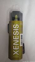 Photo of packaging showing Xenesis branding and yellow-tinted bulb inside transparent plastic case