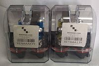 Two packs of H13 bulbs in transparent plastic cases with Xenaakyy branding and barcode labels.