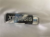 Single boxed Xenesis branded light bulb in clear packaging, showing blue-tinted bulb.