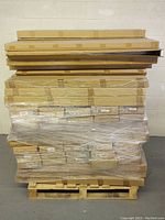 Pallet of multiple cardboard boxes wrapped in plastic, containing factory packaged spoilers.