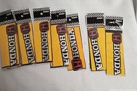 Eight Honda auto decals in factory packaging with yellow backing and red Honda 'H' logos