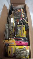 Full box showing various packages of car decals, badges, and lights packed together.