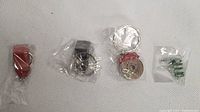 Five assorted key chains in various designs and colors in plastic packaging